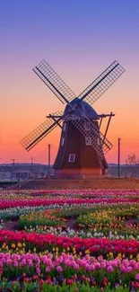 Scenic windmill and tulip field under a colorful sunset sky.