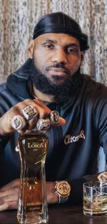 Athlete posing with tequila and rings.