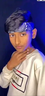 Young person with bandana on dark backdrop.