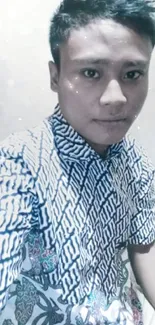 Man wearing a stylish batik shirt in a light blue themed wallpaper.