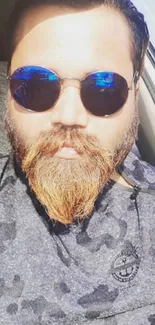 Portrait of bearded man wearing sunglasses in bright sunlight.