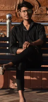 Person sitting on a bench with a mural background.