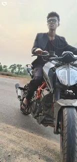 Man on motorcycle with sunset backdrop.