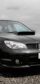 Elegant black car parked on gravel in scenic landscape.