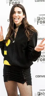 Stylish woman posing in black jacket with peace signs.