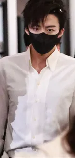 Person wearing a black mask and white shirt in a stylish setting.