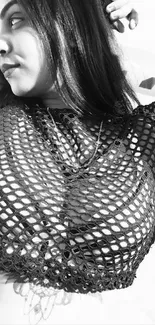 Black and white portrait of a person wearing a mesh top.