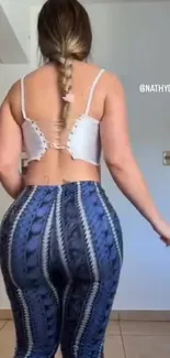 Stylish woman in blue leggings and white top.