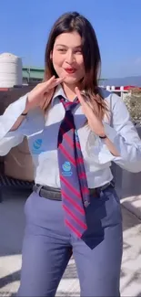 Person in a stylish blue outfit with tie posing outdoors.