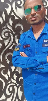 Portrait of man in blue shirt with artistic background pattern.