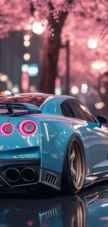 Blue sports car with cherry blossoms in the city at night.