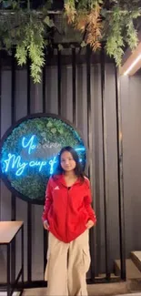 Cafe setting with neon sign and person in red jacket.