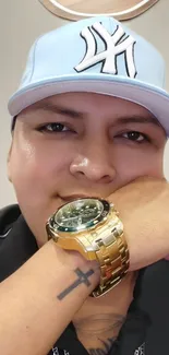 Person with stylish cap and gold watch.