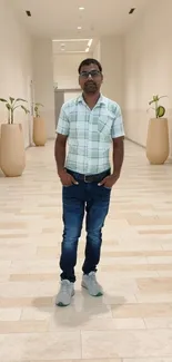 Casual man posing in stylish hallway with plants and modern decor.