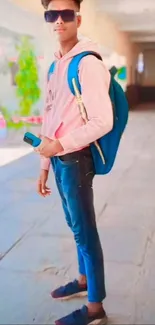 Person in stylish casual outfit with a blue backpack outdoors.