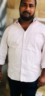 Man in light pink shirt with abstract background.