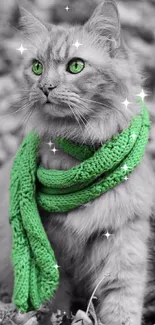 Stylish cat with vibrant green eyes and matching scarf against monochrome leaves.