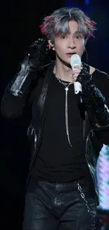 Stylish performer on stage holding a microphone.