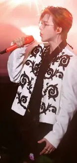 Vibrant performer in ornate outfit with microphone on stage.