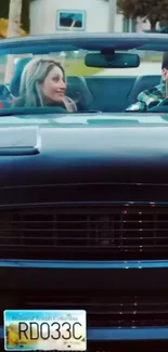 Convertible car ride with two smiling passengers.