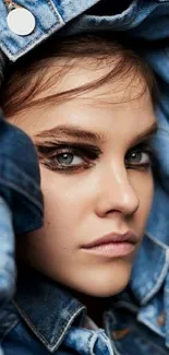 Woman in denim jacket with striking makeup, capturing a stylish portrait.