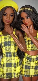 Two dolls in yellow plaid outfits posing fashionably.