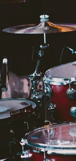 Dark red drum set on stage in a captivating wallpaper.