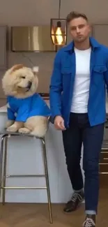 Fashionable man and dog in matching blue outfits in a modern kitchen.