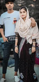 Stylish couple posing outdoors in trendy attire.