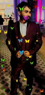 Man in burgundy suit under vibrant lights.