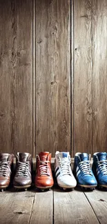 Colorful football boots lined up against wooden background.