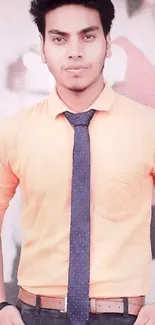 Man in orange shirt with blue tie, stylish formal look.