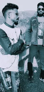 Two stylish friends in denim with mountains backdrop and blue tone.