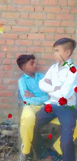 Two boys sitting against a brick wall with red roses.