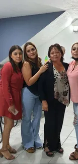 Four women in stylish outfits at an indoor gathering.