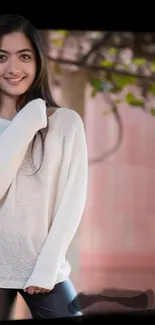 Girl in white sweater with pink and green background.