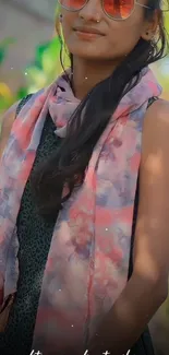 Girl wearing sunglasses and a colorful scarf outdoors.