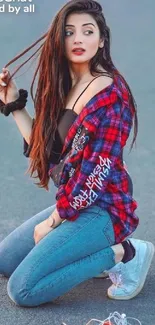 Stylish girl in red and blue outfit sitting on the road.