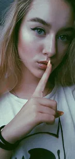 Young woman with finger over lips.