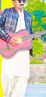 Stylish man in traditional attire playing a red guitar outdoors.