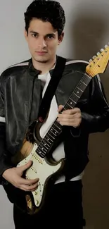 Musician with electric guitar and leather jacket in stylish pose.