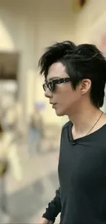 Man in black shirt with stylish sunglasses on a blurred urban street.