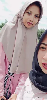 Two friends wearing fashionable hijabs in selfie.