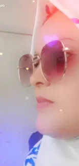 Portrait of a person in sunglasses and hijab with light pink ambiance.