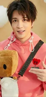 A trendy guy in a pink hoodie with plush toy and cloud background.