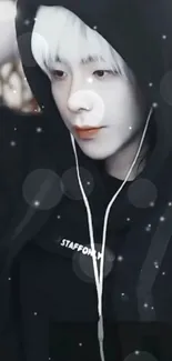 A stylish person in a black hoodie with earphones on.