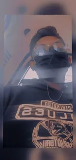 Person in a hoodie with mask and glasses on phone wallpaper.