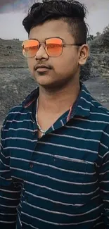 Stylish portrait of a young man with sunglasses in a scenic landscape.