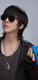 Person in leather jacket with sunglasses and a blue device.