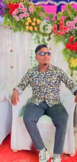 Stylish man amid colorful floral decor.